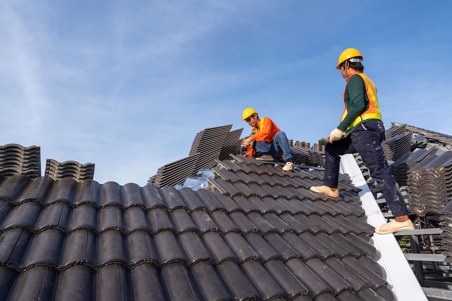 teamwork 2 roofers worker protective uniform wear gloves using air pneumatic nail gun installing concrete roof tiles top new roof building construction 61243 1556